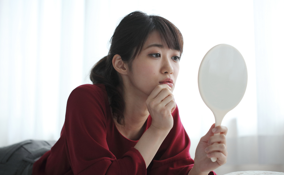 鏡を見る女性|ムクノキ歯科