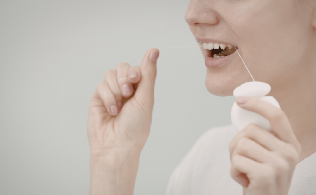 フロスを使う女性｜ムクノキ歯科